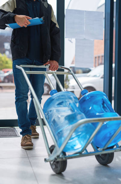 Cropped shot of a courier making a bottled water delivery in an office